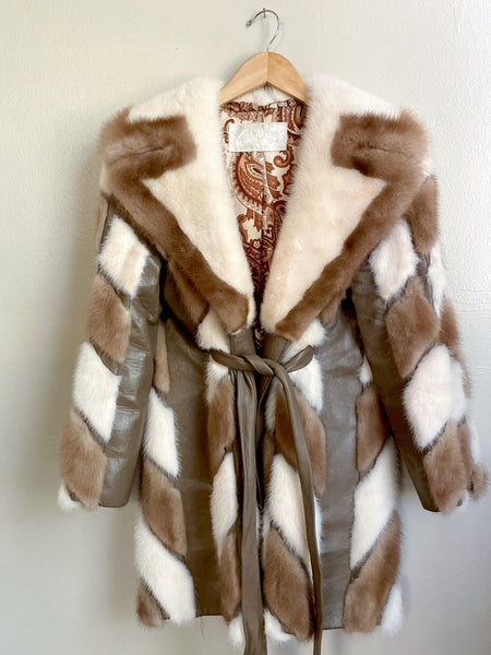 Vintage patchwork fur with leather trim circa 1970s. The belt goes through holes on the sides of the jacket and ties in front. Small. 